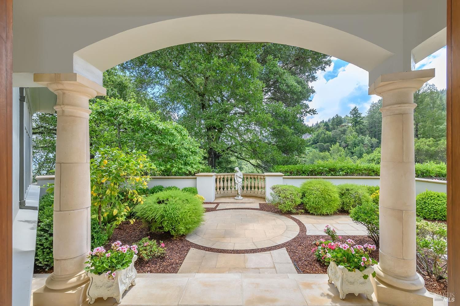 Columned terrace looking out to formal garden with marble statuary
